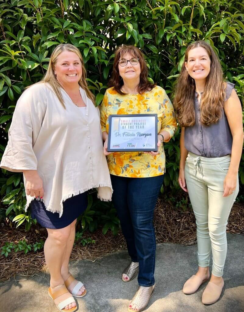 UWF Lewis Bear Jr. College of Business Professor Dr. Felicia Morgan showcases her award certificate with Florida SBDC's Christa Wilson and Aly Lawson.