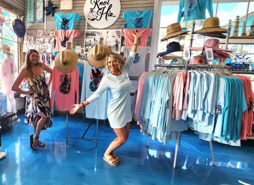 Jeannie Pope poses with wholesale customer Toni LaBatt in front of Jeannie's UV-protection apparel on display at Harborwalk Marina in Destin, Florida.