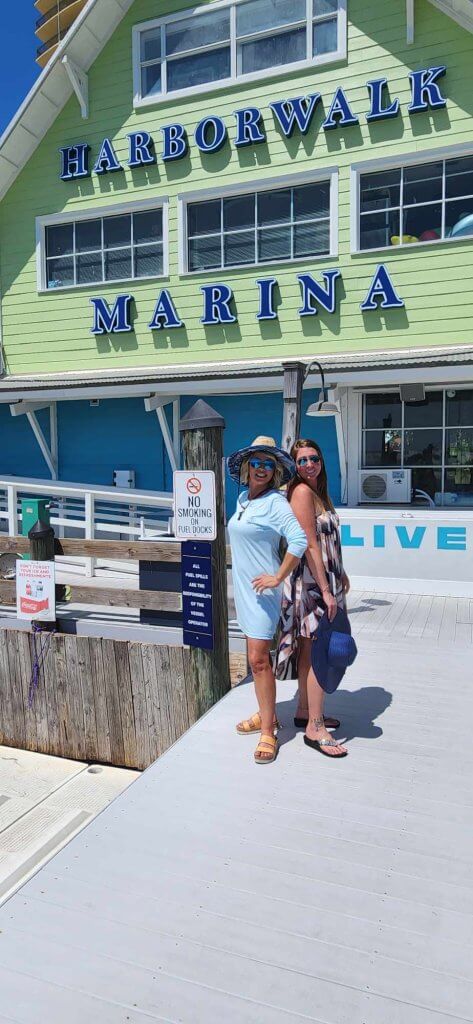 Jeannie Pope, owner of Knot His 850, poses with her wholesale customer Toni LaBatt, Retail Operations Manager at Harborwalk Marina, in front of the marina in Destin, Florida.