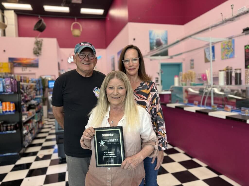 City Councilmember Allison Patton, District 6, congratulates Alan and Judy with their award plaque at their store.
